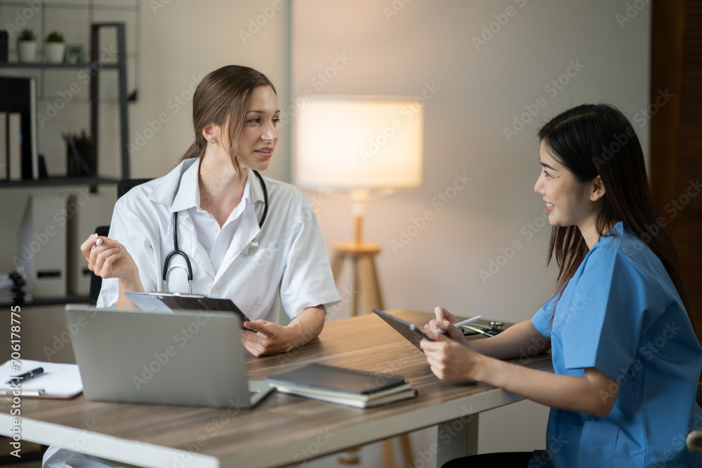 Female doctor sitting at work looking at the history of patients in the clinic or in the hospital Female doctor sitting at work looking at the history of patients in the clinic or in the hospital