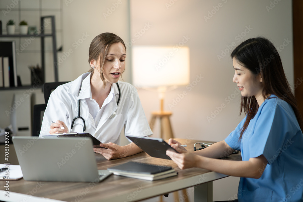 Female doctor sitting at work looking at the history of patients in the clinic or in the hospital Female doctor sitting at work looking at the history of patients in the clinic or in the hospital