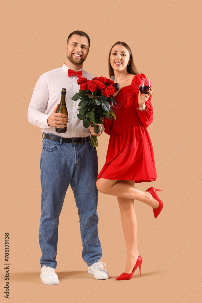 Lovely couple with bouquet of roses and wine on beige background. Valentine's Day celebration Lovely couple with bouquet of roses and wine on beige background. Valentine's Day celebration