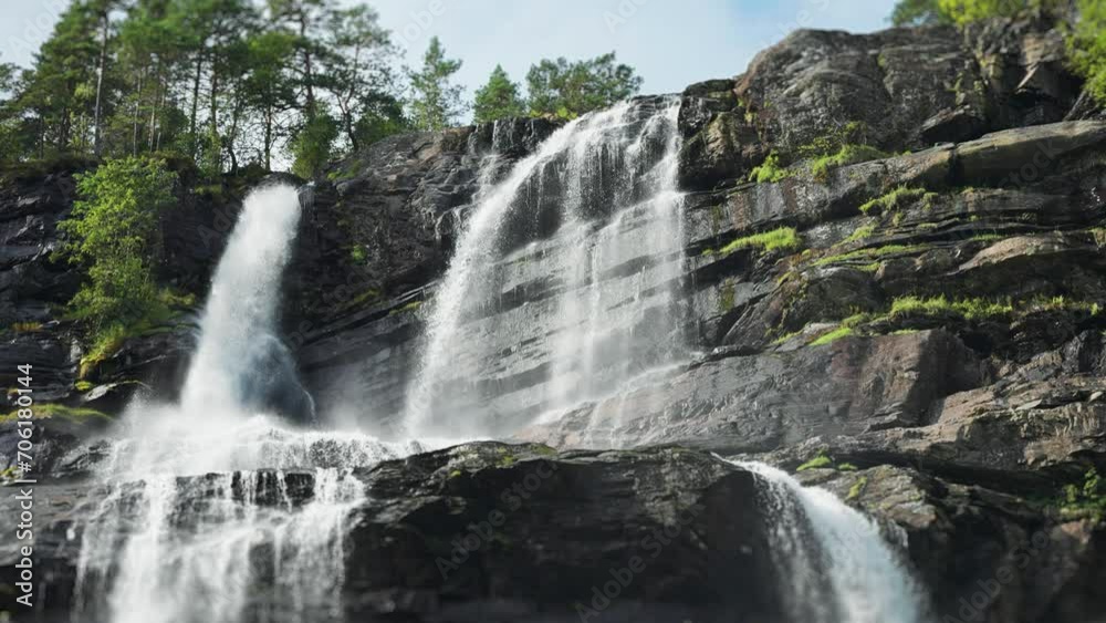 Tvindefossen waterfall cascades over the rocky cliffs. Slow-motion video. Tvindefossen waterfall cascades over the rocky cliffs. Slow-motion video.