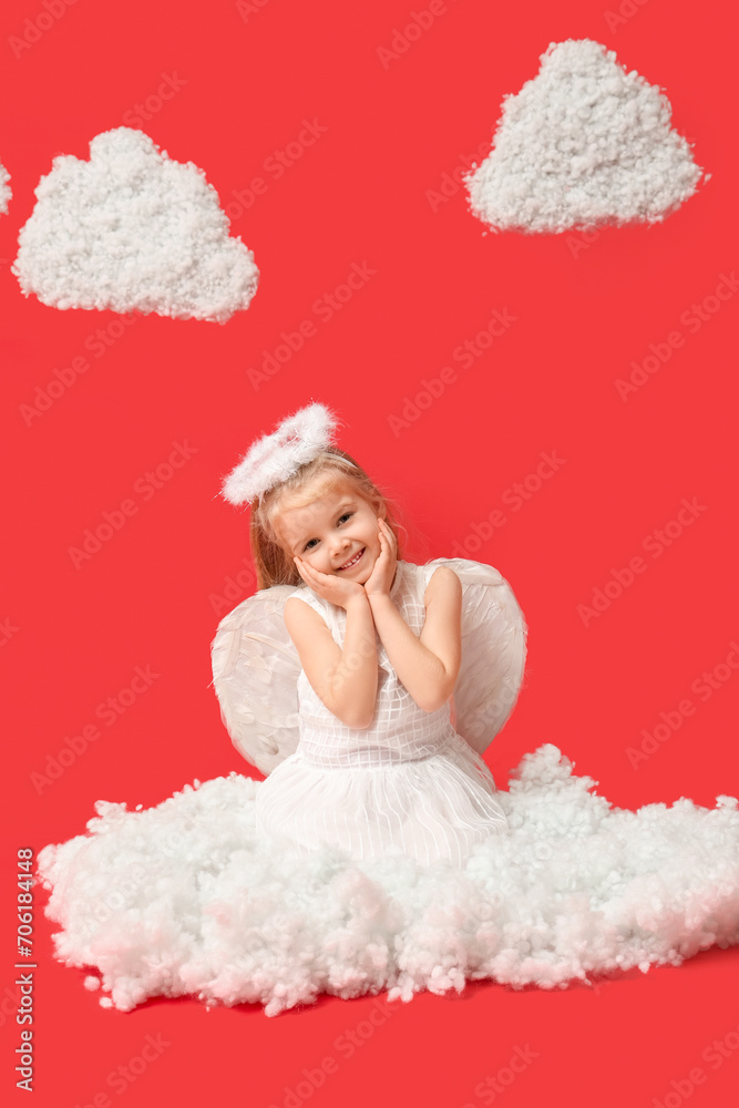 Cute little girl dressed as cupid with clouds sitting on red background. Valentine's Day celebration