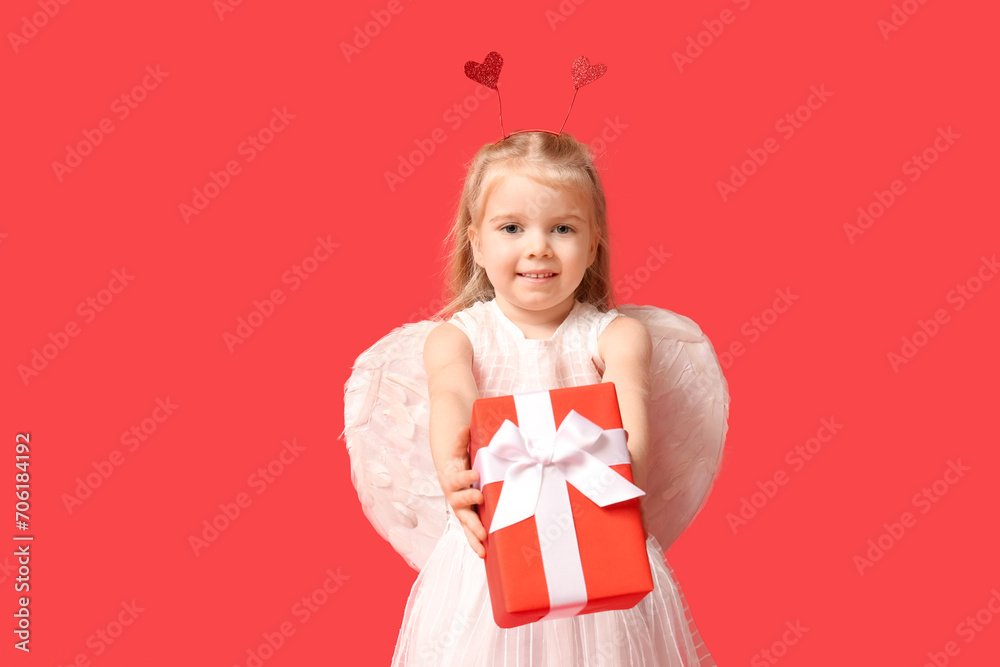 Cute little girl dressed as cupid with gift box on red background. Valentine's Day celebration Cute little girl dressed as cupid with gift box on red background. Valentine's Day celebration