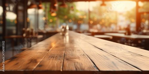 Empty wooden table with blurred background of coffee bar or cafe.