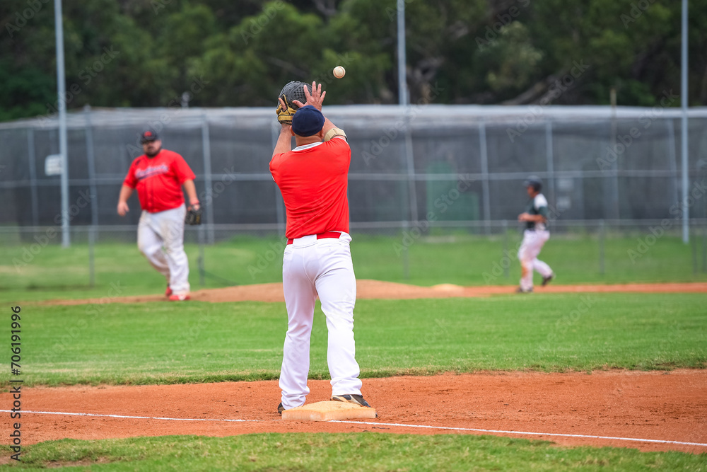 Baseball game, first baseman catching the ball thrown from the infielder during the ball game.