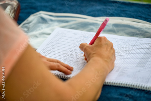 Baseball game, close up of the scorer filling up the score sheet during the ball game. photo