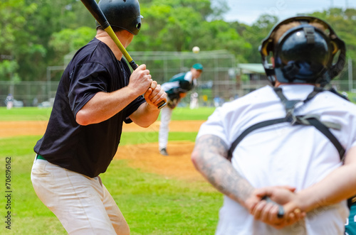 Men playing baseball game. Batter getting ready to hit a pitch during ballgame on a baseball diamond