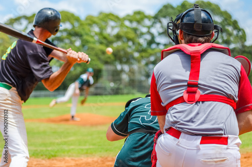 Men playing baseball game. Batter getting ready to hit a pitch during ballgame on a baseball diamond