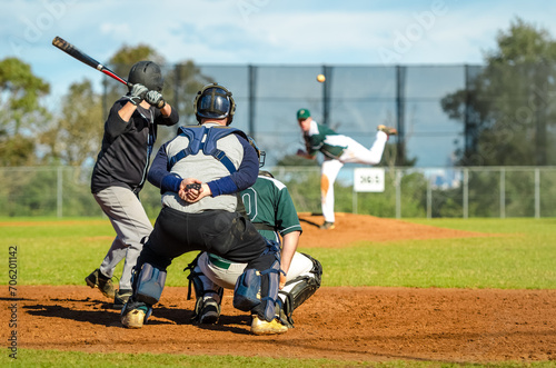 Men playing baseball game. Batter trying to hit a pitch during ballgame on a baseball diamond