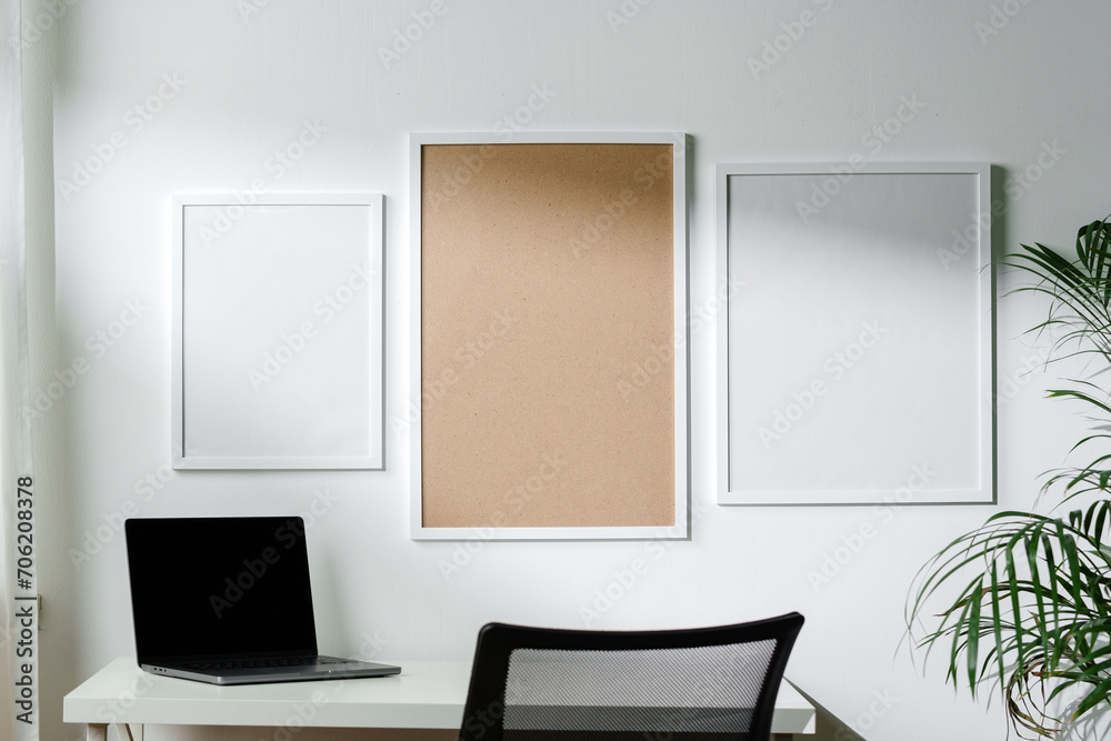 Empty frames on the wall above the working table in the office Empty frames on the wall above the working table in the office