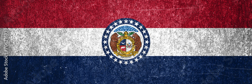 Close-up of the grunge Missouri State flag. Dirty Missouri State flag on a metal surface.