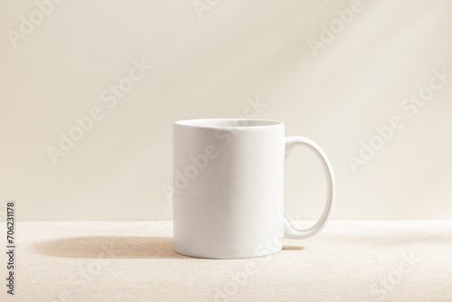 White mug isolated on wood background. Drinking water. White mug. Beverage. Fabric surface. Simplicity. Minimalist object. Space for text. Mockup. 