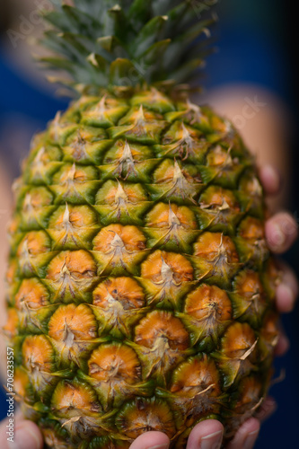 Dorodny apetyczny ananas trzymany w ręce 