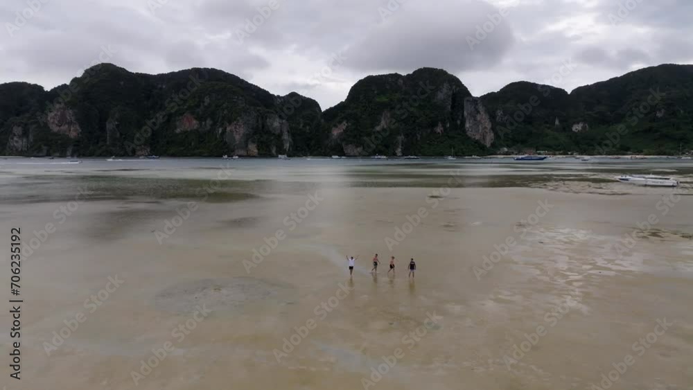Drone footage from PhiPhi islands in Thailand footage of incredible Thai landscapes incredible nature with insane rocks, beaches, hills, ocean adn boats. 5 model man on a beach walking.