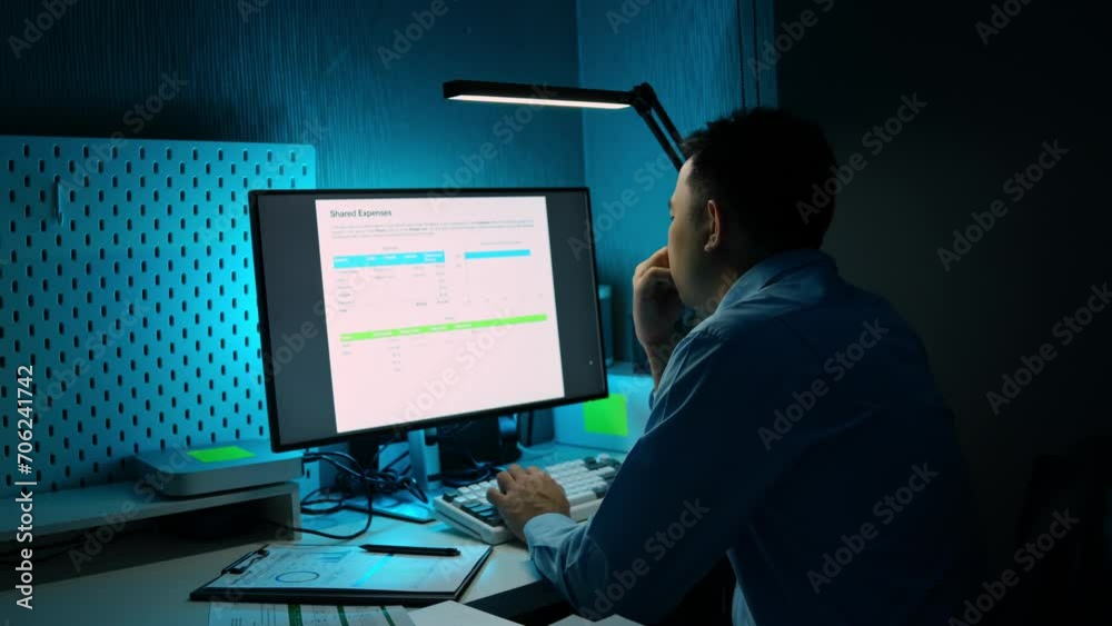 Asian male businessman sits and analyzes the situation in a financial report. Compare data in private offices Using financial advisor concepts, business strategy analysis, and ideas.