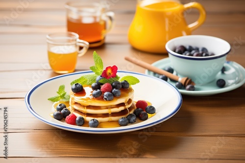 breakfast pancakes with maple syrup and fresh berries on ceramic plate