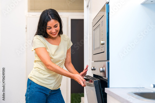 Woman cooking pizza at home in the oven