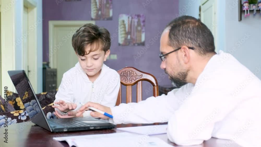 Arabic man teaching his kid in home during quarantine and supporting his kid learning Arabic man teaching his kid in home during quarantine and supporting his kid learning