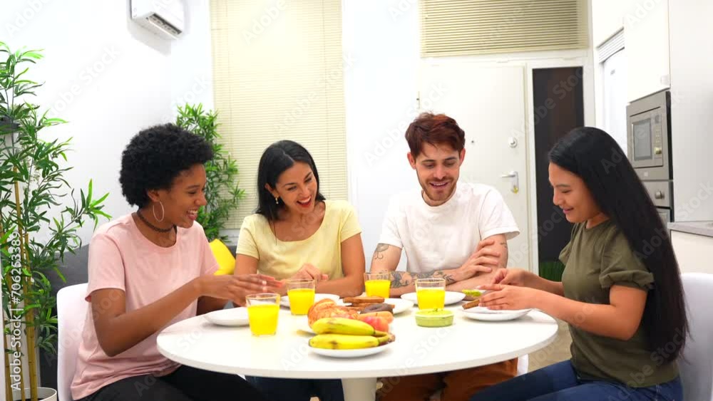 Multi-ethnic friends having healthy breakfast together at home sitting and sharing table Multi-ethnic friends having healthy breakfast together at home sitting and sharing table