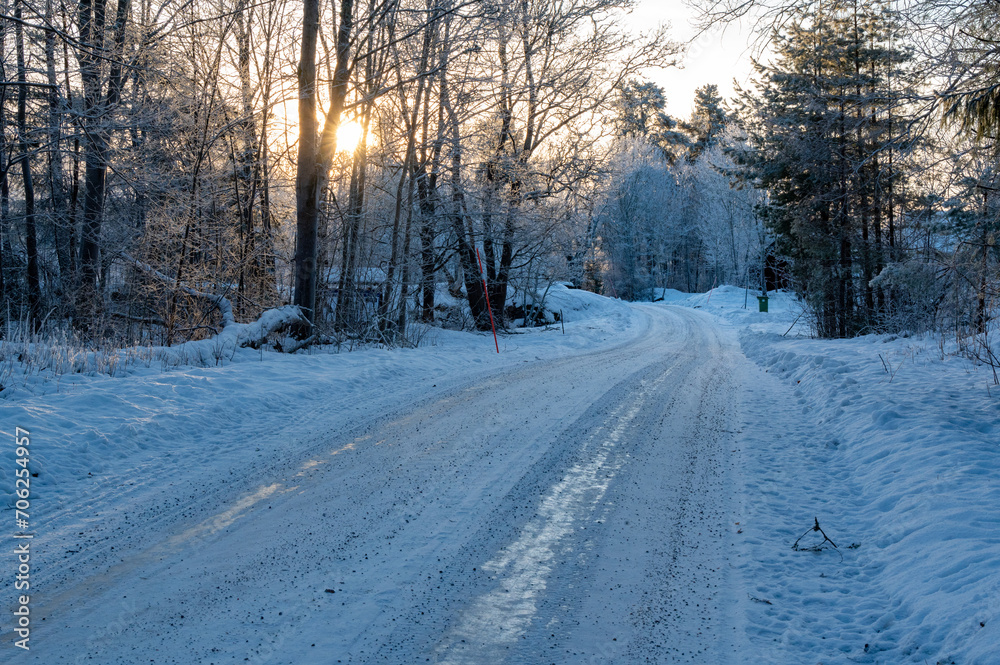 Backlight over icy and snowy winter road