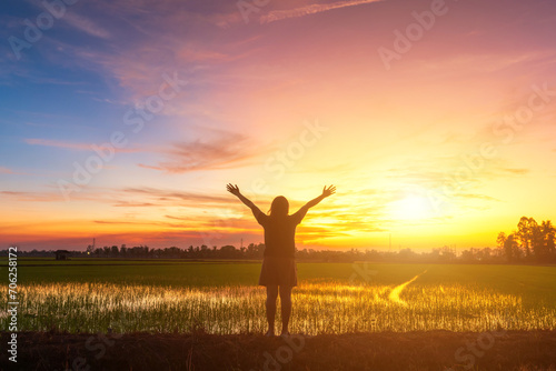 Scenic view landscape of woman relaxing in summer in mud and water reflection with Twilight blue bright and orange yellow dramatic sunset sky in beach cloudscape air background.People freedom style.