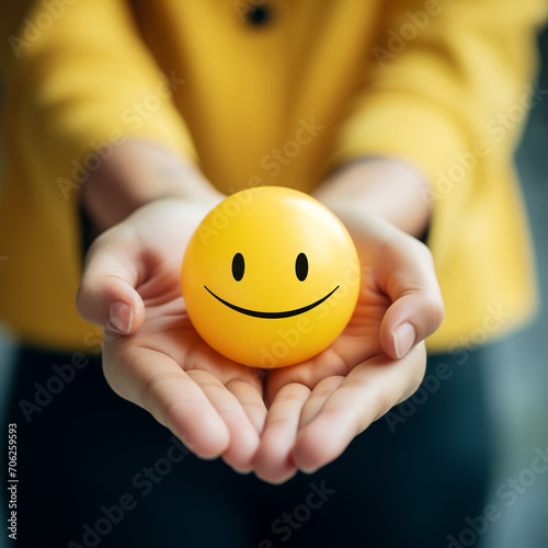 Hands holding yellow happy smiley face for medical care concept. mental health positive thinking