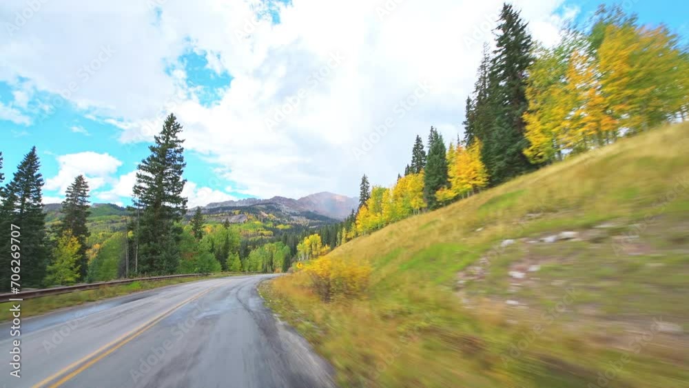 Kebler Pass, Colorado car driving vehicle shot on scenic drive paved winding road in autumn fall, aspen pine tree forest woods Kebler Pass, Colorado car driving vehicle shot on scenic drive paved winding road in autumn fall, aspen pine tree forest woods