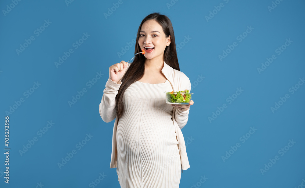 Portrait of pregnant asian woman, isolated on blue background Portrait of pregnant asian woman, isolated on blue background