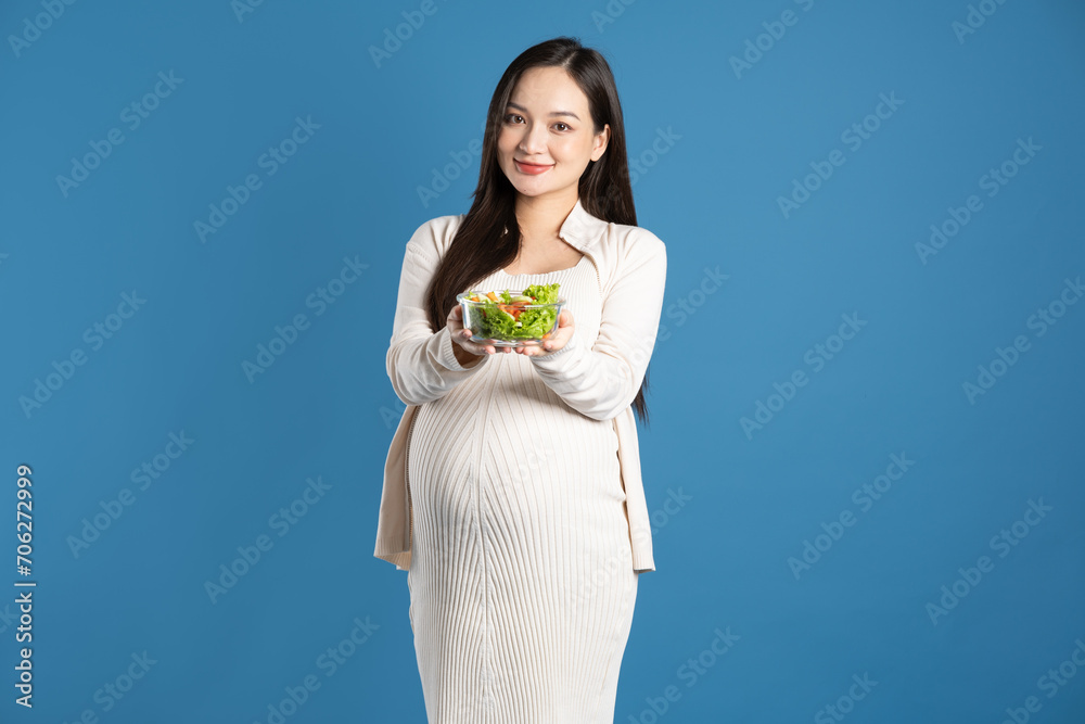 Portrait of pregnant asian woman, isolated on blue background Portrait of pregnant asian woman, isolated on blue background