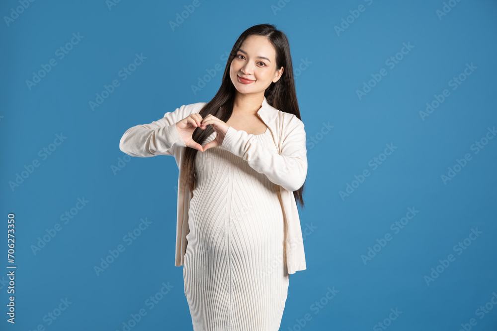 Portrait of pregnant asian woman, isolated on blue background Portrait of pregnant asian woman, isolated on blue background
