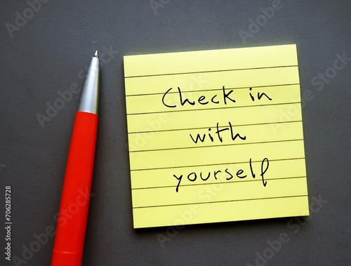 Note paper on gray background with handwritten text - Check in with yourself - carving out time each day to ask yourself how you’re doing