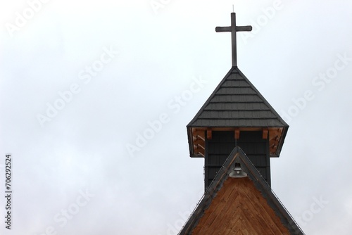 The top of the church with a cross against the background of a cloudy sky