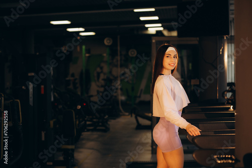 Young sporty woman running on machine in the gym