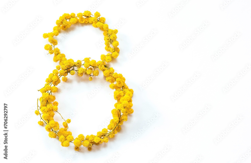 Obraz premium International Women's Day. A banner, a flyer, a beautiful postcard for March 8th. Yellow mimosa flowers in the shape of the number eight on a white isolated background.