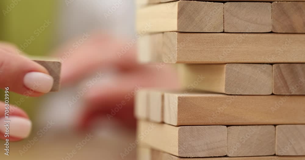 Closeup of hand holding wooden Jenga game Closeup of hand holding wooden Jenga game