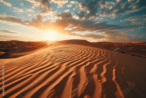 A beautiful sunset scene with the sun setting over the sand dunes. Perfect for travel and nature themes