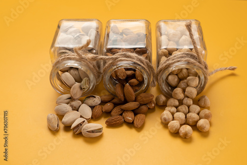 Mix of nuts: almonds,pistachios and hazelnuts on a yellow background.Template