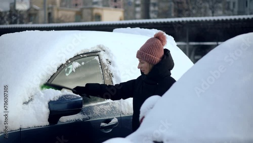 Driver scraping snow off car's window photo