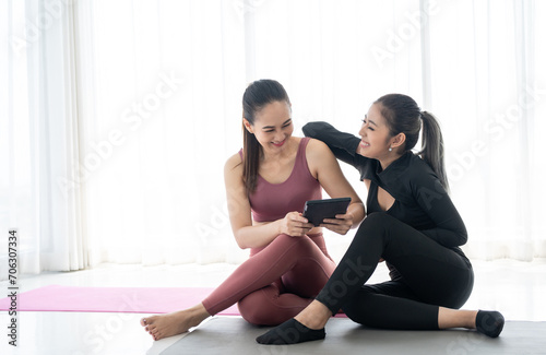 Two beautiful women relax after work out yoga. Fitness women in sportswear. Cheerfully sporty females workout and exercise in sports class lesson.
