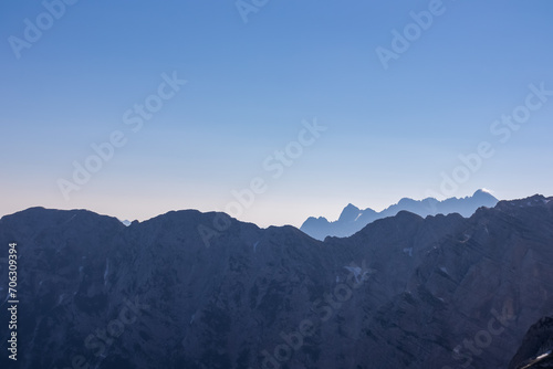 Silhouette of mountain peaks of wild Julian Alps seen on scenic hiking trail to majestic summit Mangart, Friuli Venezia Giulia, border Italy Slovenia, Europe. Hiking wanderlust in alpine wilderness