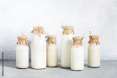 Non dairy plant based milk in bottles and ingredients on light background. Alternative lactose free milk substitute
