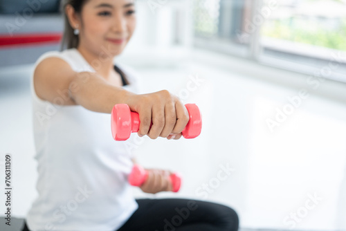 Fresh feeling female training and exercise wearing sport wear fit body. Attractive asian young fitness woman lifting dumbbell weights workout at home in living room