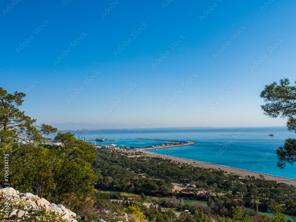 View of the sea and skyline from the mountains of Turkey. Blue sky, blue sea, forest and Antalya city in the background. Beautiful cityscape.