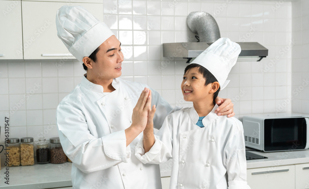 Young handsome asian man chef cooking breakfast in the kitchen. Happy asian man preparing food with ingredient. Chef in uniform in the kitchen.