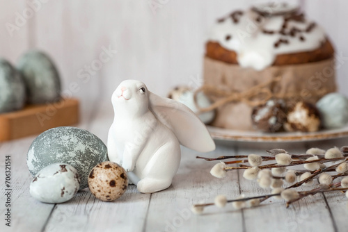 Stylish grey Easter eggs in the colors of marble, concrete, willow branches, Easter bunnies and Easter cake on a white wooden background. Coloring eggs for Easter. The feast of bright Easter. photo