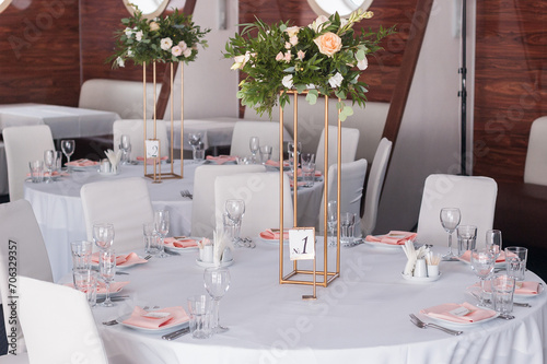 Table setting for a wedding banquet. Small restaurant hall. Round served tables