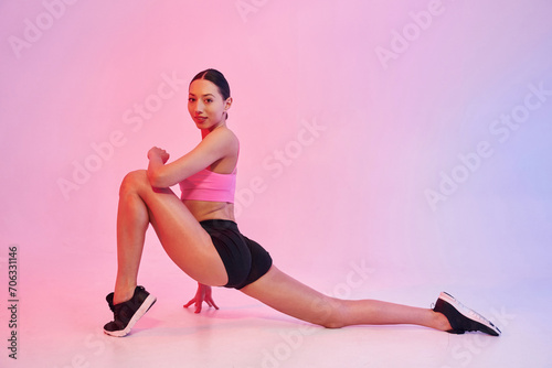 Professional fitness woman in sportive clothes against background in studio