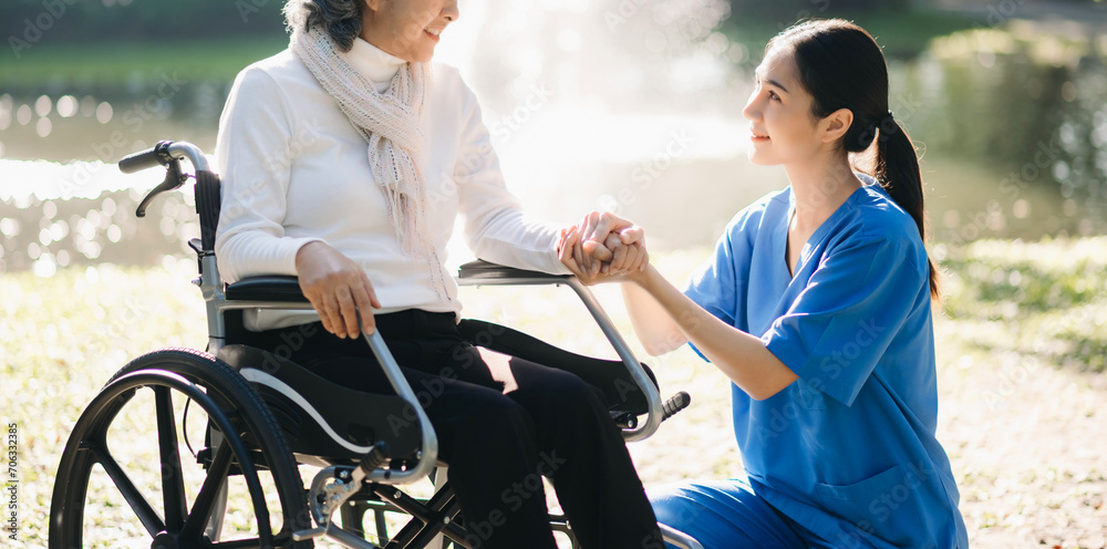 Elderly asian senior woman on wheelchair with Asian careful caregiver and encourage patient, walking in garden. with care from a caregiver. and senior health insurance Elderly asian senior woman on wheelchair with Asian careful caregiver and encourage patient, walking in garden. with care from a caregiver. and senior health insurance