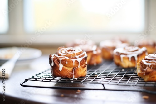 cinnamon rolls with icing on a wire rack photo