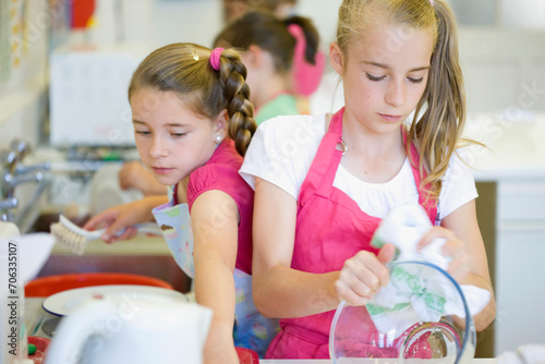 Young girls in cookery class washing up
 photo