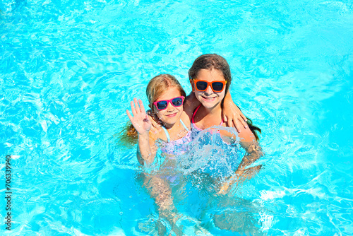 Two cute girls playing in swimming pool